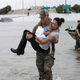 Houston Police SWAT officer Daryl Hudeck carries Catherine Pham and her 13-month-old son Aiden after rescuing them from their home surrounded by floodwaters from Tropical Storm Harvey on Aug. 27.